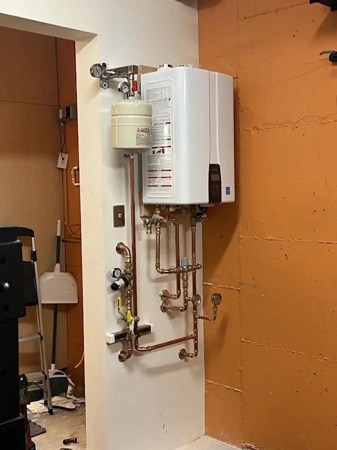 Plumbing technician inspecting water heater connections in Lincoln Village